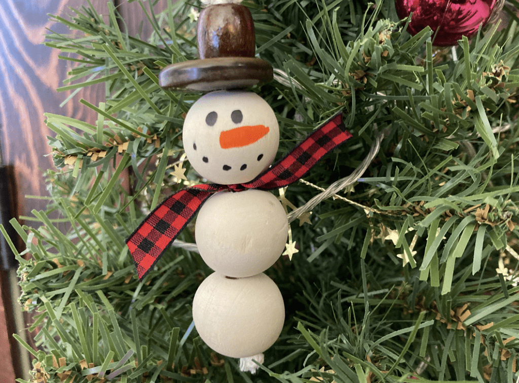 finished snowman ornament hanging in a tree